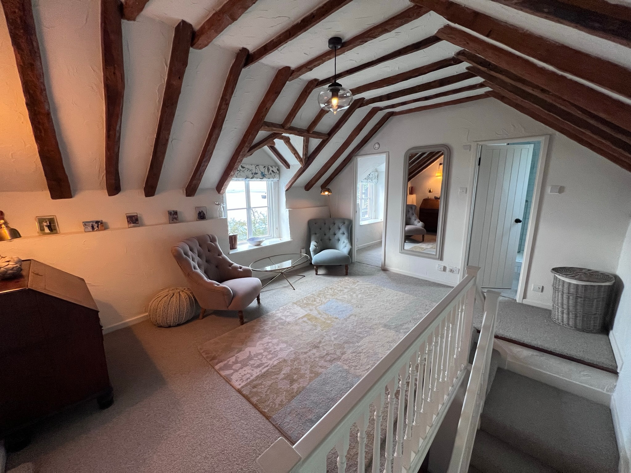 Open-plan attic sitting area with exposed beams