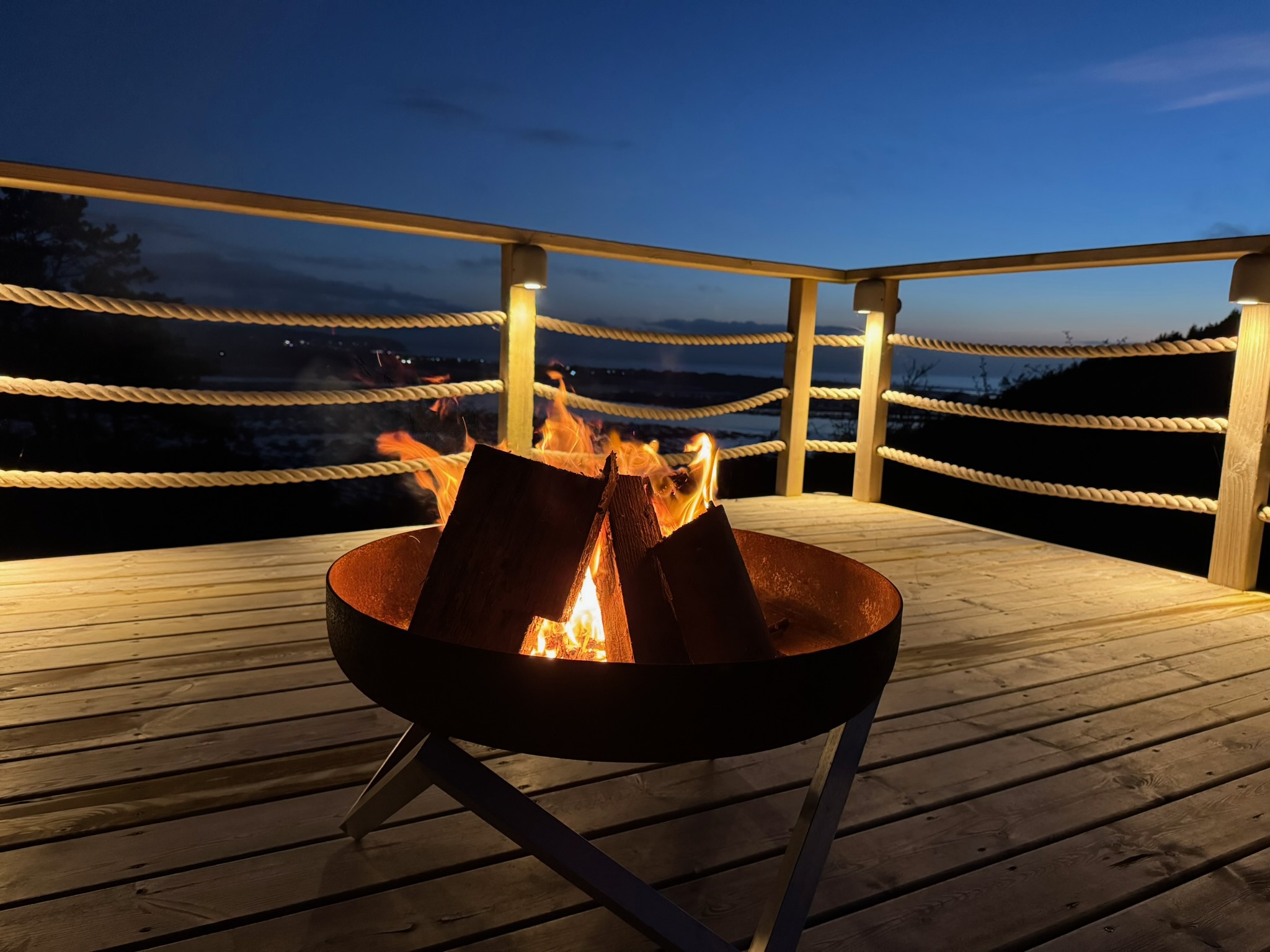 Fire pit on the deck overlooking the bay at twilight
